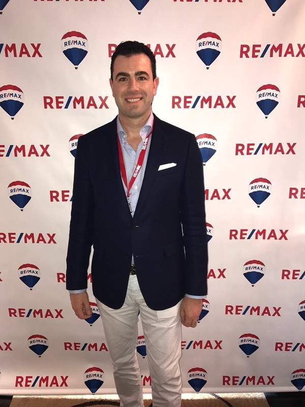 Charles Perreault devant le mur RE/MAX