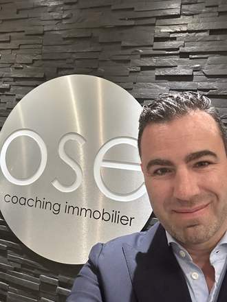 Charles Perreault devant l'enseigne d'OSE Coaching Immobilier